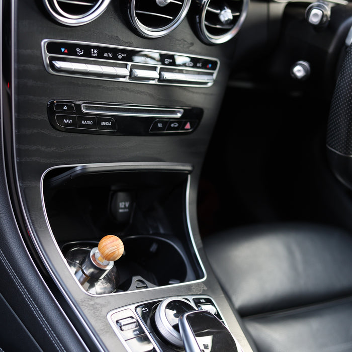 Overhead view of a Fireball luxury fragrance diffuser fitted in the centre cup holder of a Mercedes-Benz GLC.