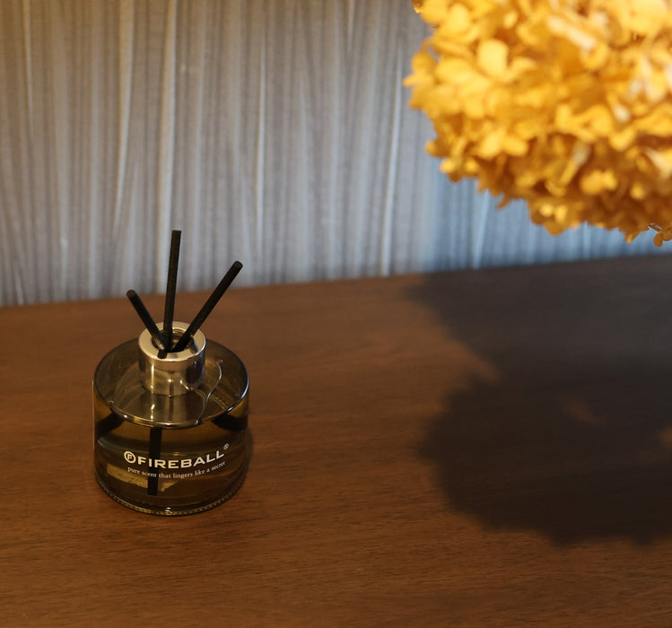 Fireball luxury fragrance diffuser with reed sticks displayed on a wooden entrance table in a modern home.