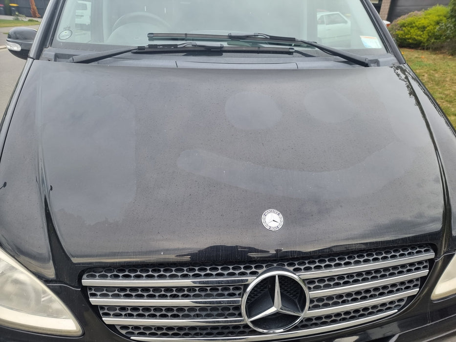 Smiley face pattern showing water spots removed from black van paint using Autostolz Water Spot Remover